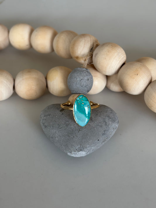 Gold diamond ring in teal